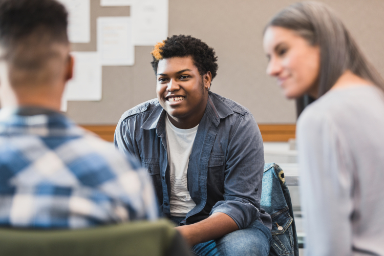 Teacher smiles as teen welcomes new student