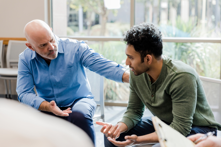 two gentlemen sat at a table in discussion