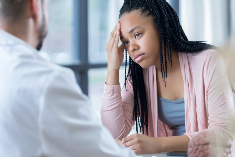 Hopeful teenage girl listens to physician's migraine treatment plan