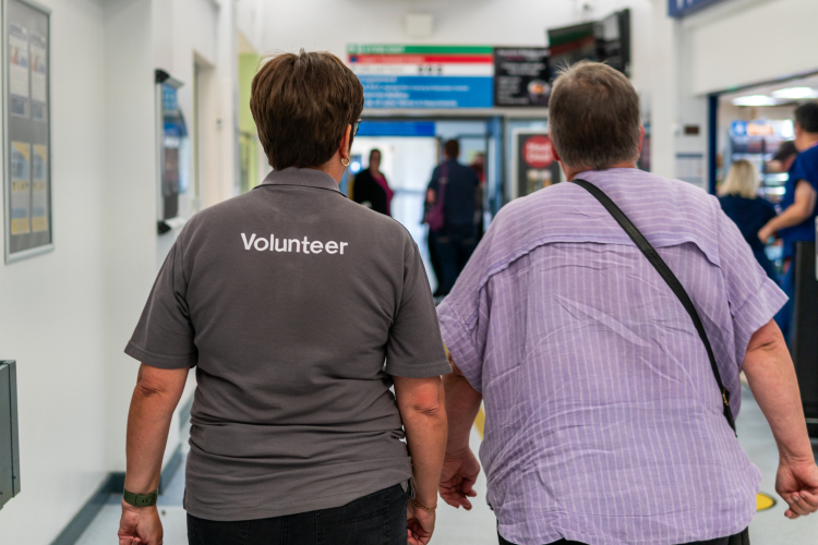 Volunteer with patient in hospital corridor