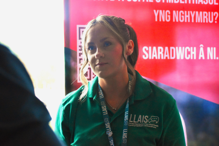 female member of staff listening to someone sharing thir experience of health and social care services