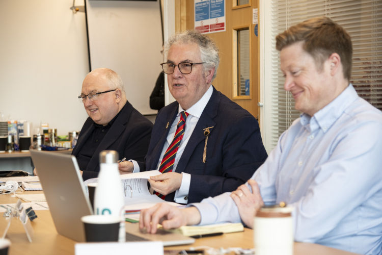 male members of the board smiling at a board meeting