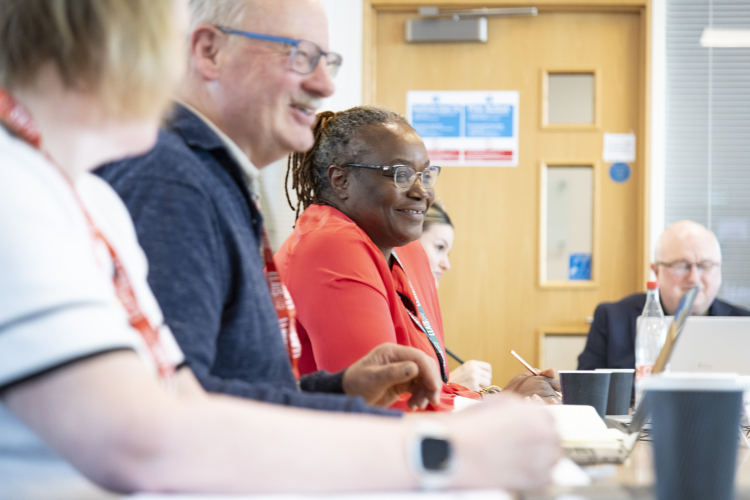 image of our three members of the board, smiling next to eachother at a meeting