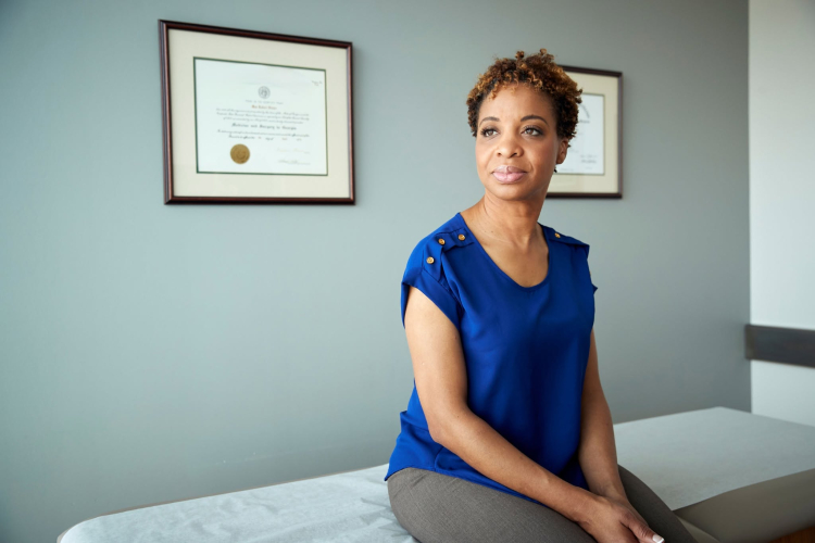 Lady sits up on doctor's bed, looking hopeful