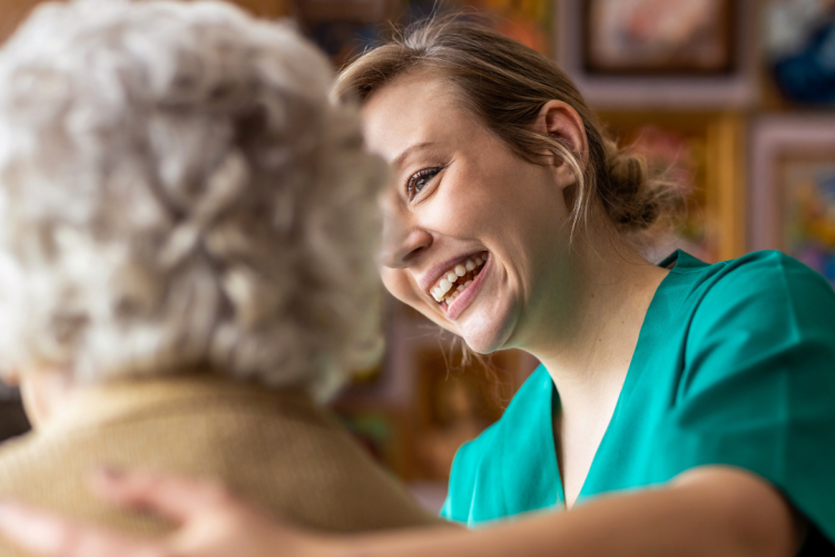 carer smiling looking after an elderly lady