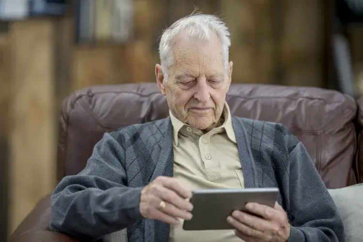 An old man using his tablet